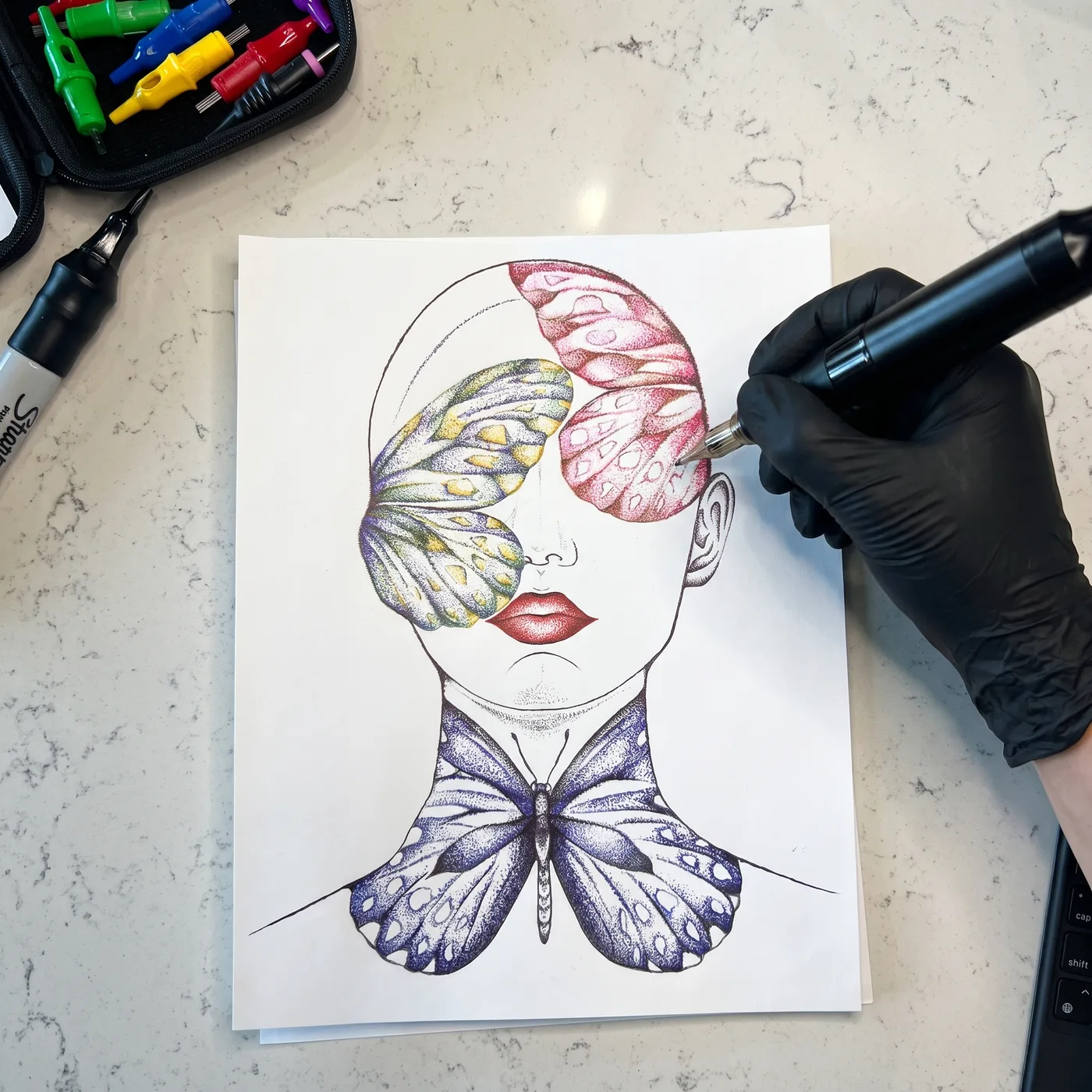 Gloved hand stippling a butterfly wing with the machine